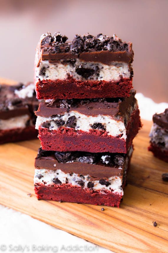 Homemade red velvet brownies layered with Oreo frosting, chocolate ganache, and topped with Oreos. Recipe at sallysbakingaddiction.com