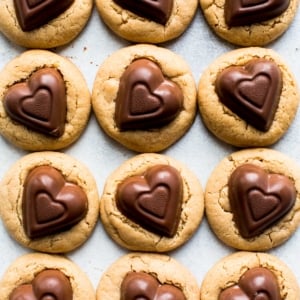overhead image of peanut butter cookies with chocolate heart candies on top