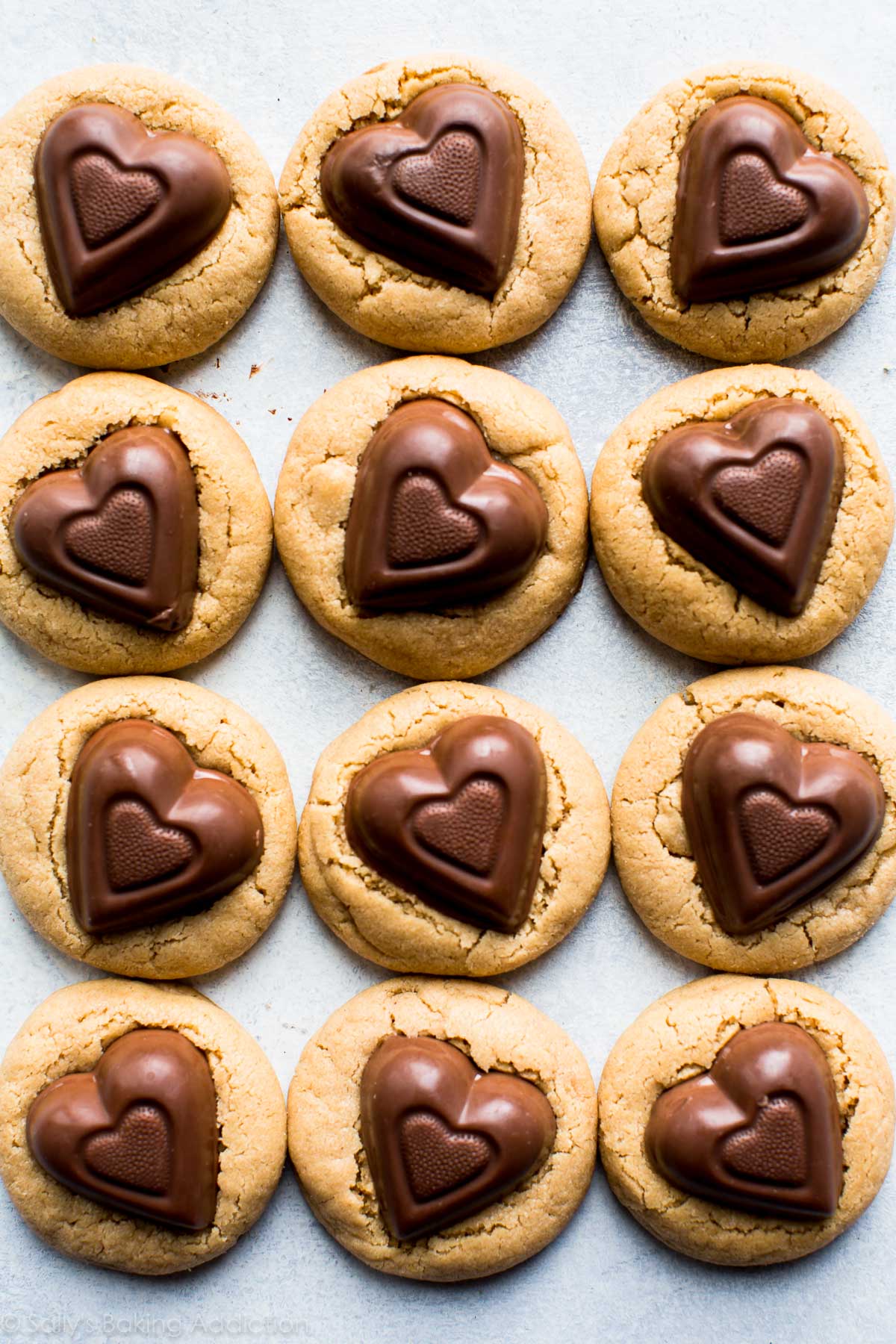 overhead image of peanut butter cookies with chocolate heart candies on top
