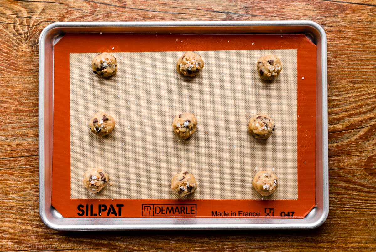 cookie dough balls arranged on baking sheet