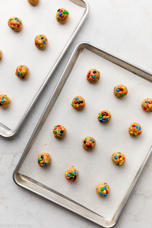 cookie dough balls on lined baking sheets.