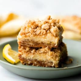 two creamy lemon crumble bars on a green plate