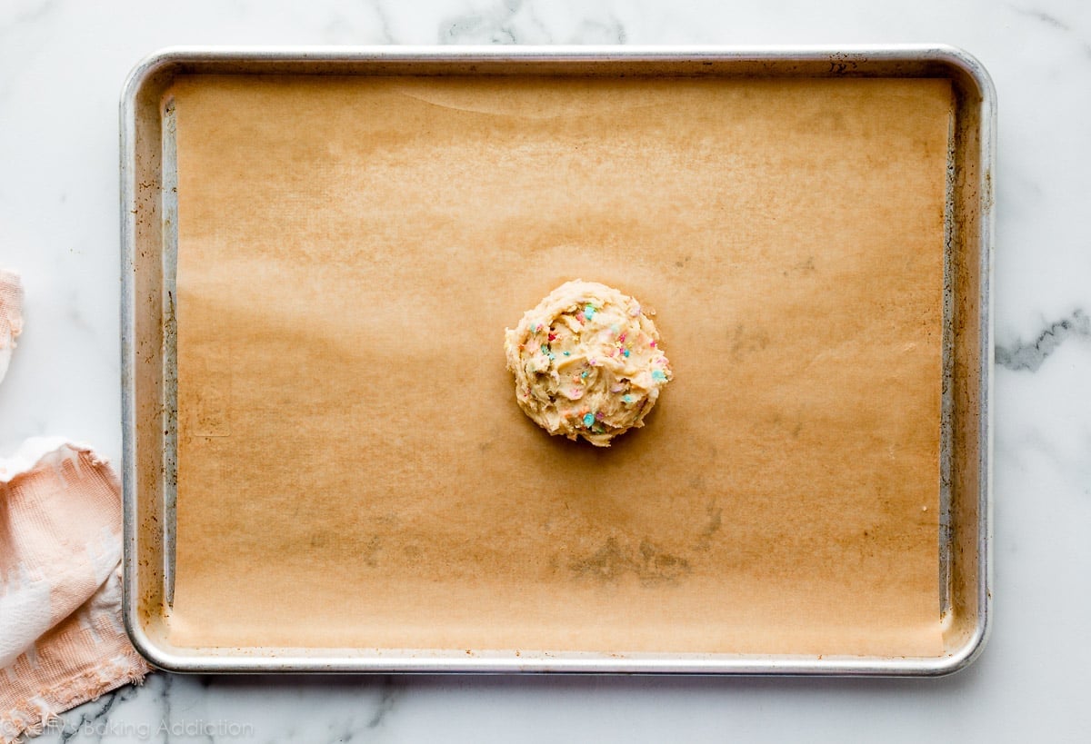 big sugar cookie dough ball on lined baking sheet