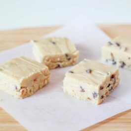 squares of chocolate chip cookie dough fudge on a wood board