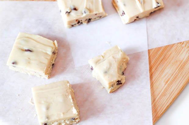 overhead image of squares of chocolate chip cookie dough fudge on a wood board