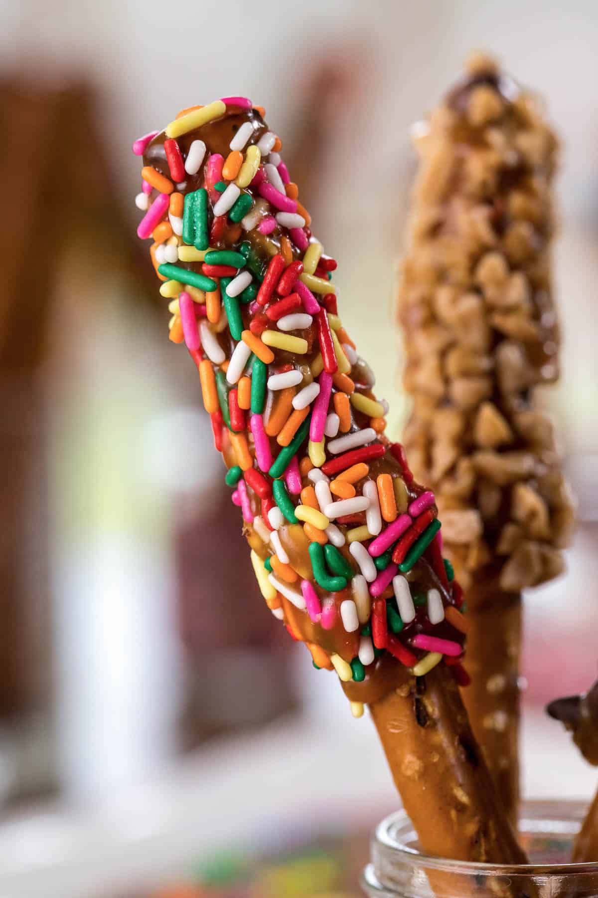 pretzel rods dipped in caramel with various toppings