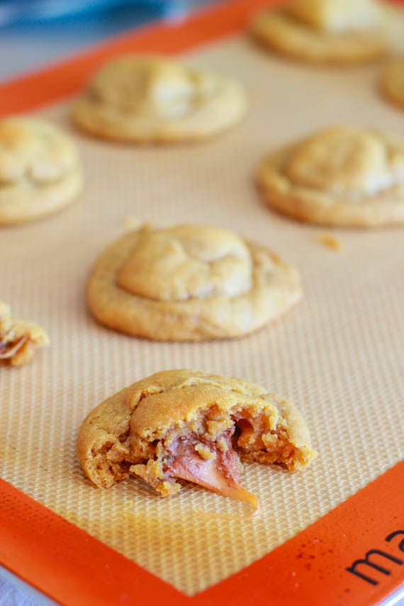 peanut butter cookies stuffed with a Rolo on a silpat baking mat
