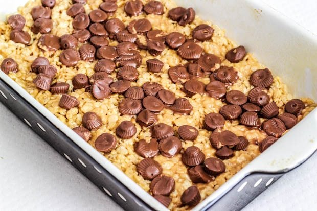 peanut butter Rice Krispies treats in a baking dish with mini peanut butter cups on top