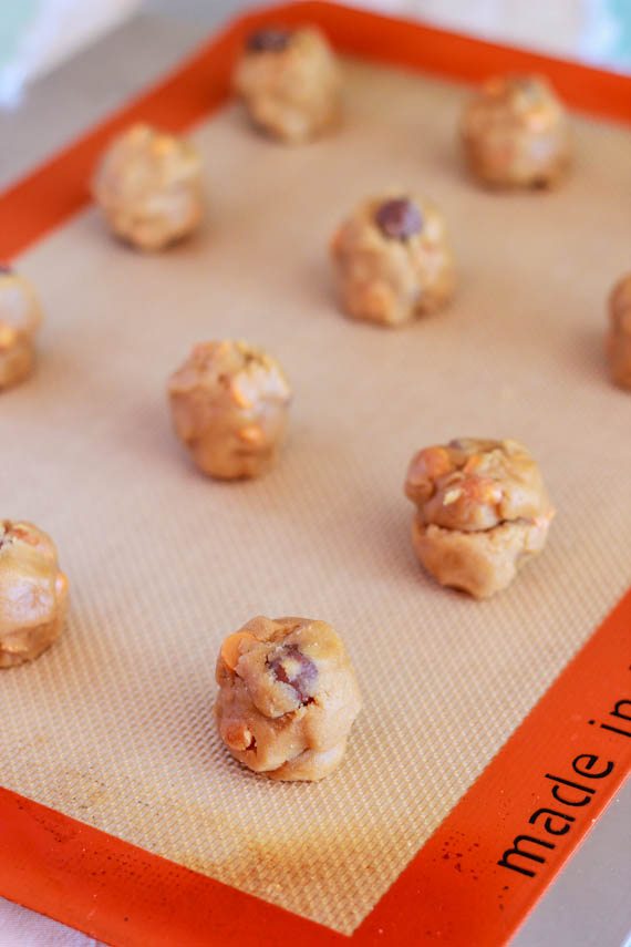 peanut butter cookie dough balls on a silpat baking mat