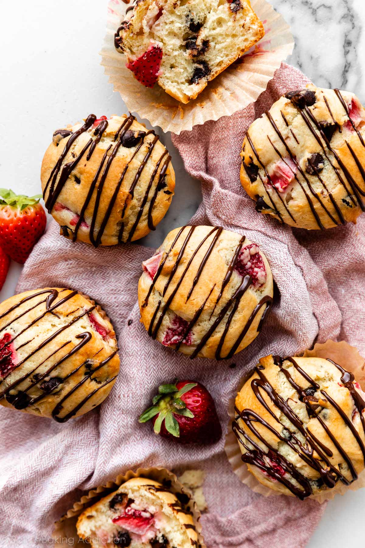 chocolate chip strawberry muffins with melted chocolate drizzle on top