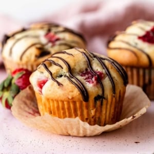 strawberry and chocolate chip muffins with chocolate drizzle on top