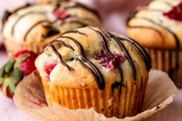 strawberry and chocolate chip muffins with chocolate drizzle on top