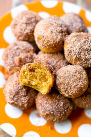 mini cinnamon sugar pumpkin muffins on an orange polka dot plate