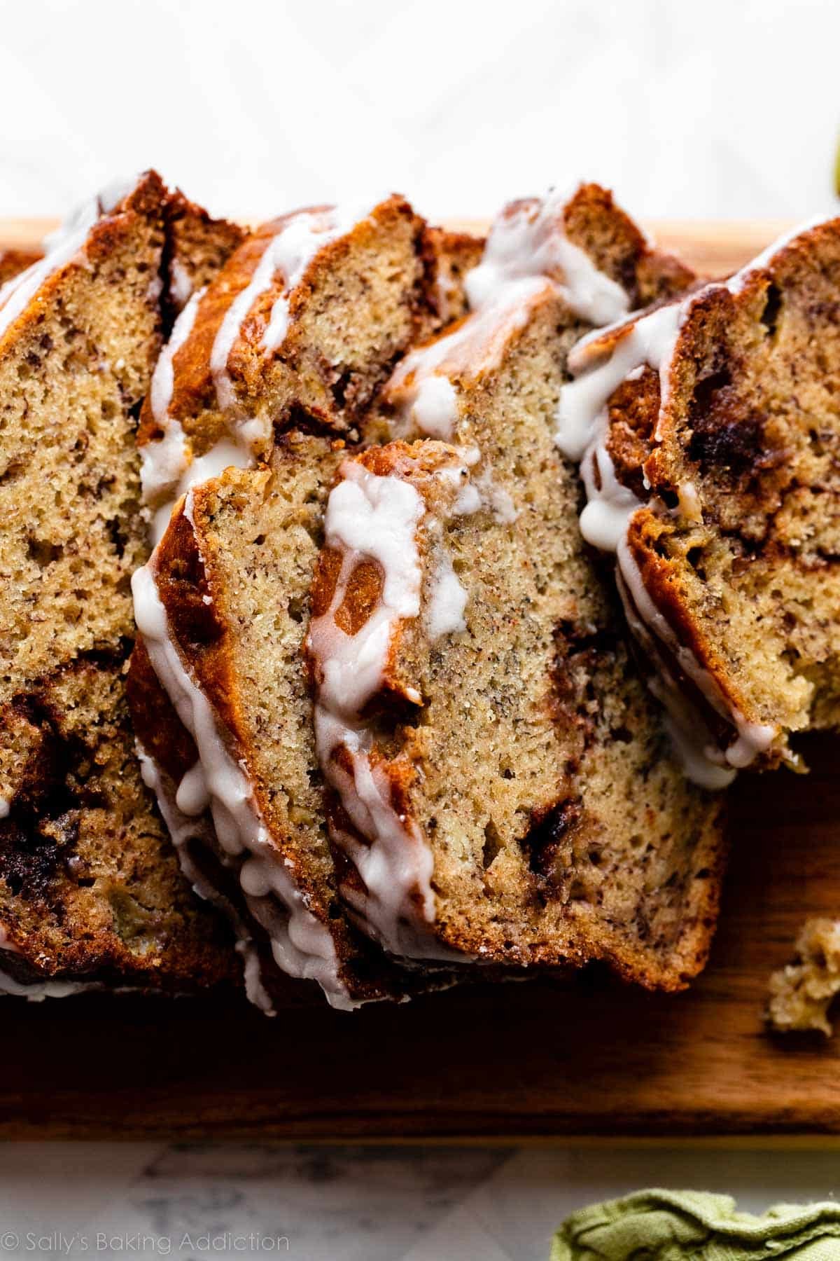 close-up photo of slices of cinnamon swirl banana bread with icing on top.