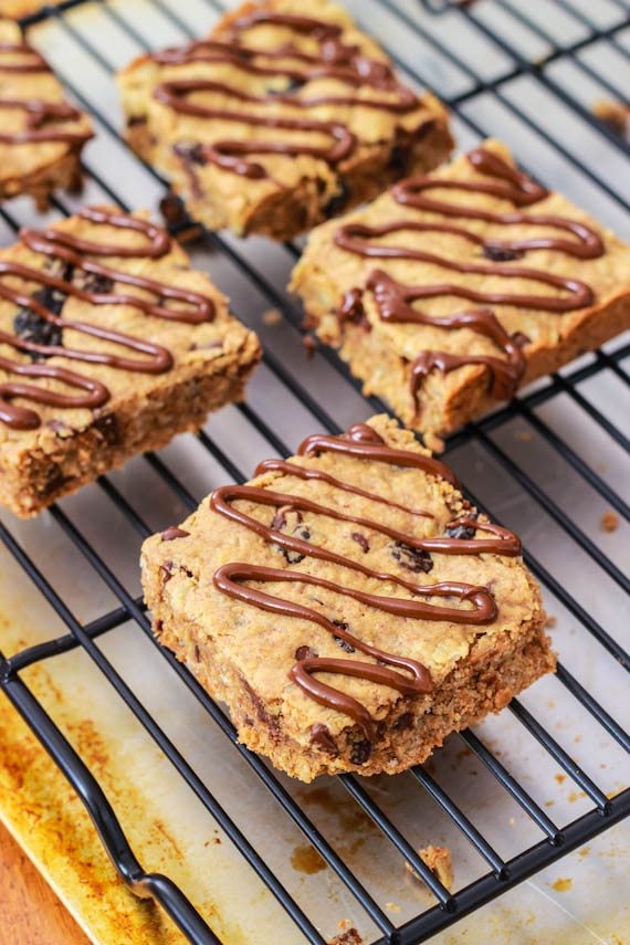 peanut butter chunk oatmeal bars with a chocolate drizzle on a cooling rack