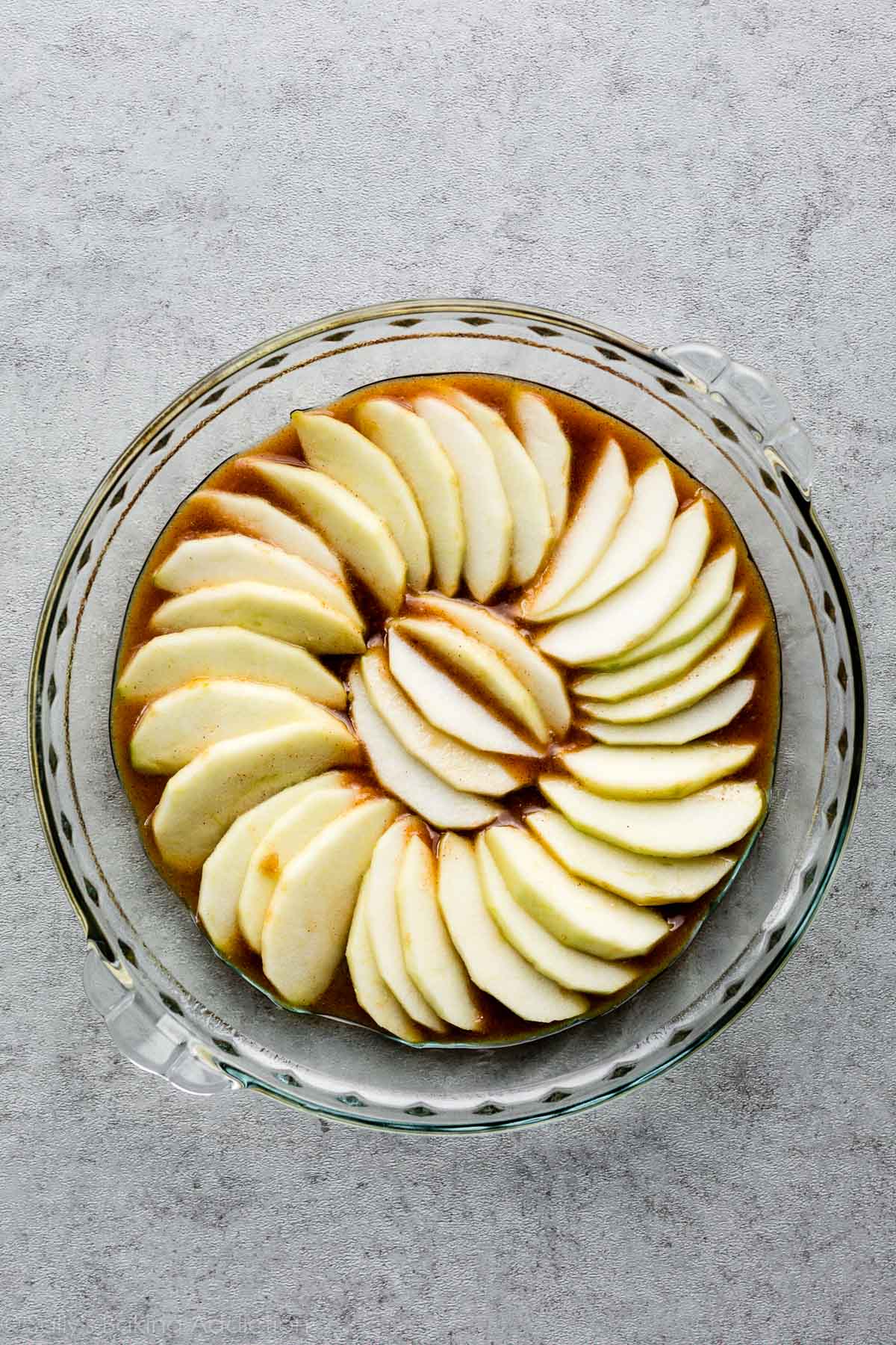apple slices arranged in glass a pie dish