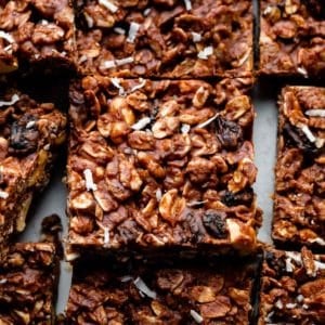 close up photo of chocolate fudge oat bars with raisins and peanuts.