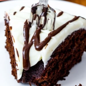 slice of chocolate gingerbread bundt cake topped with cream cheese frosting and a fork