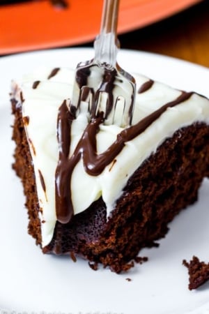 slice of chocolate gingerbread bundt cake topped with cream cheese frosting and a fork