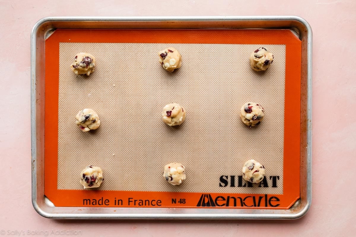 white chocolate cranberry cookie dough balls on baking sheet