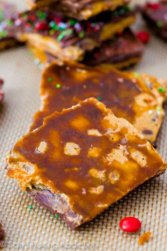 bottoms of pieces of chocolate peanut butter Saltine toffee with red and green sprinkles