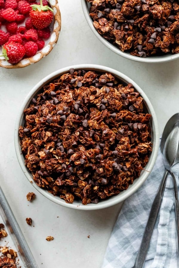 chocolate crunch granola in bowls with a side of berries.