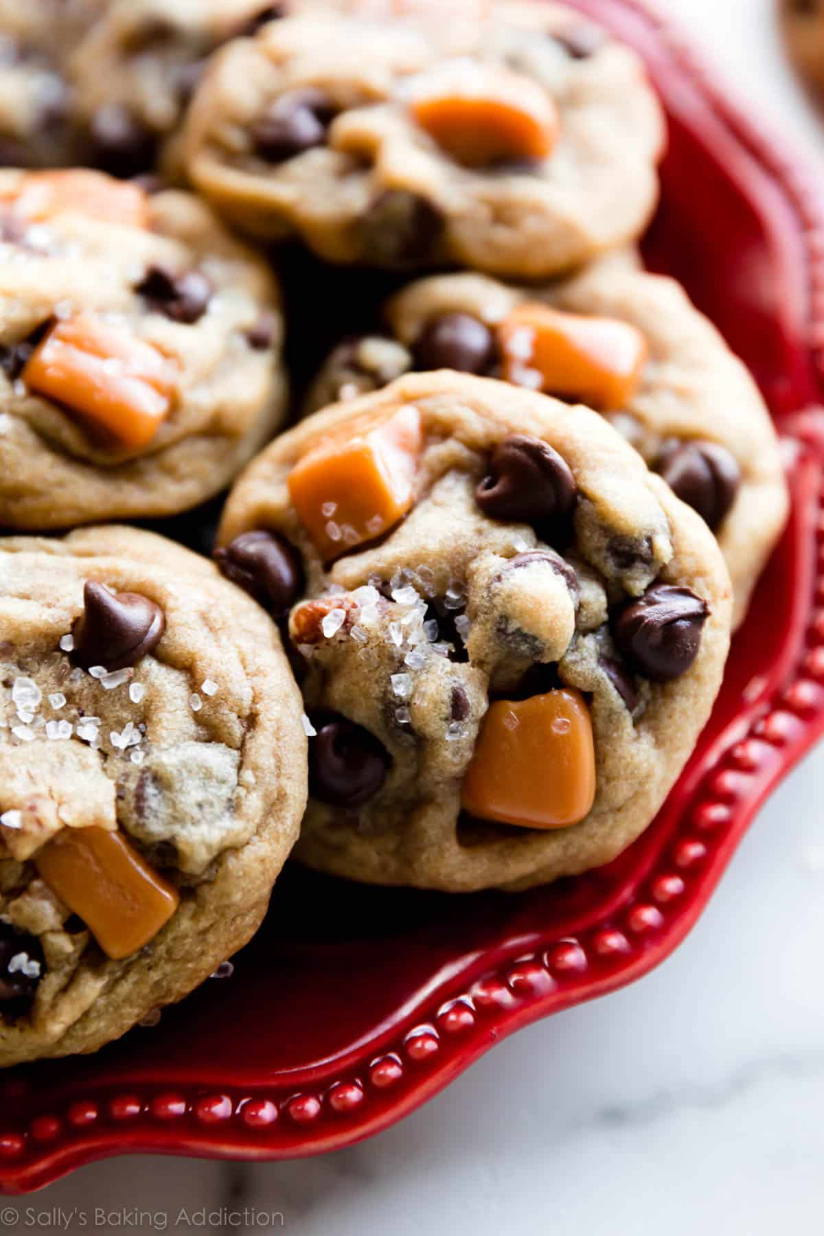 salted caramel pecan chocolate chip cookies on a red plate