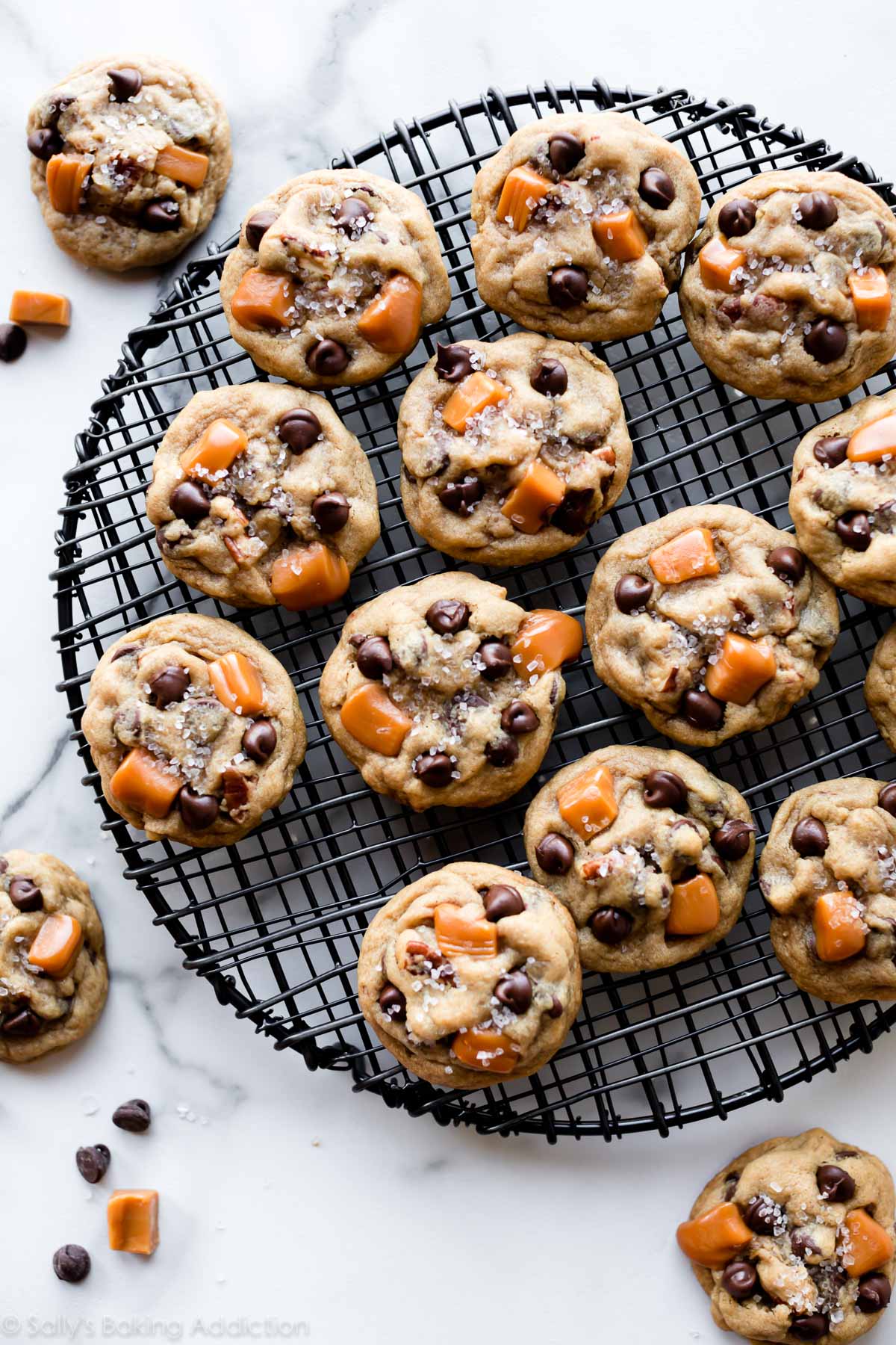 salted caramel pecan chocolate chip cookies on a round cooling rack