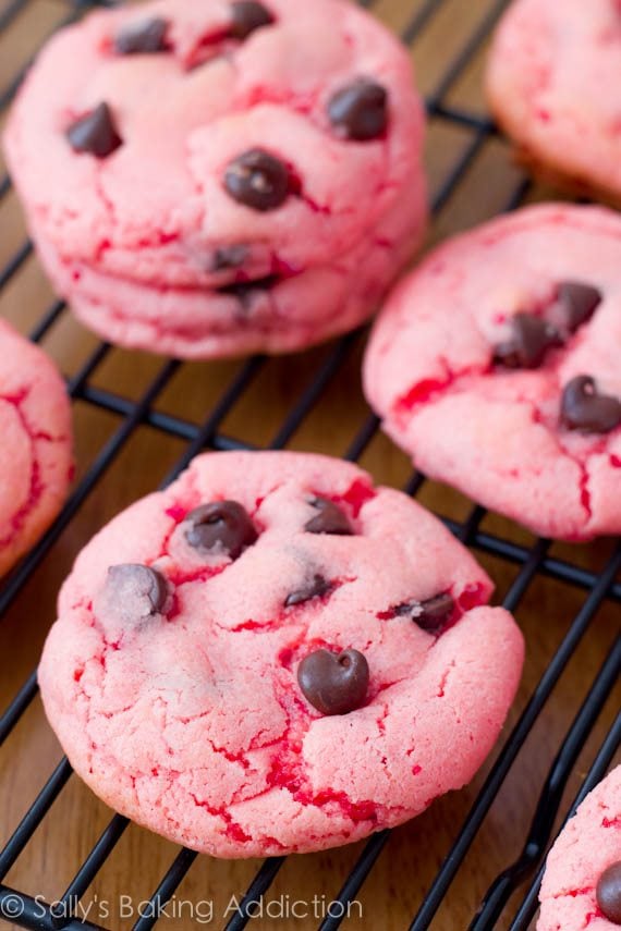 strawberry cookies with chocolate chips on a black cooling rack