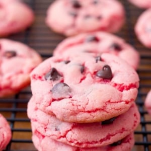 stack of strawberry cookies with chocolate chips on a black cooling rack