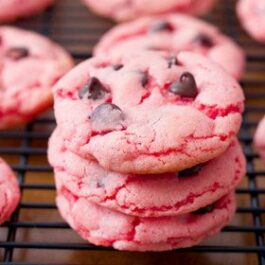 stack of strawberry cookies with chocolate chips on a cooling rack