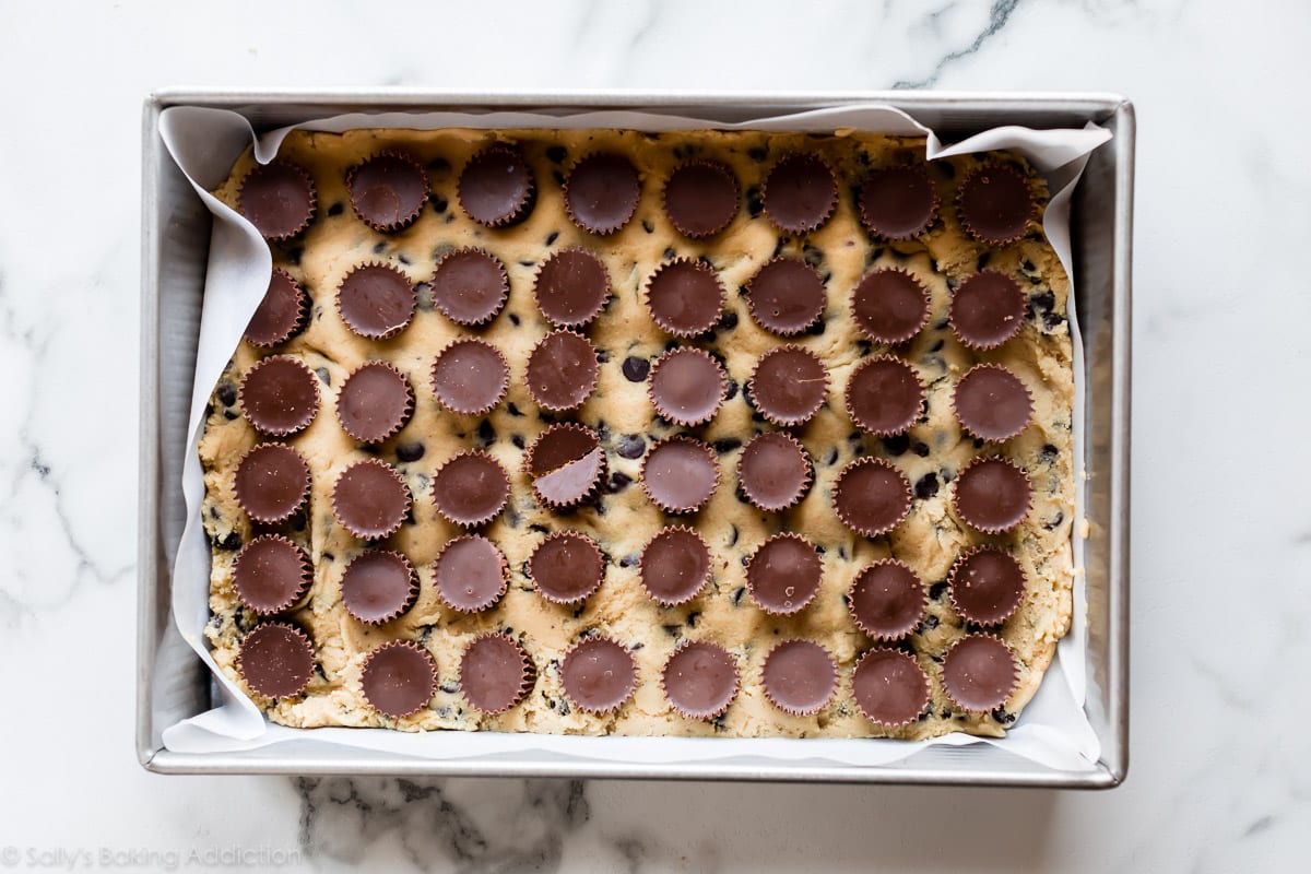 9x13 inch pan of cookie dough and peanut butter cups before baking
