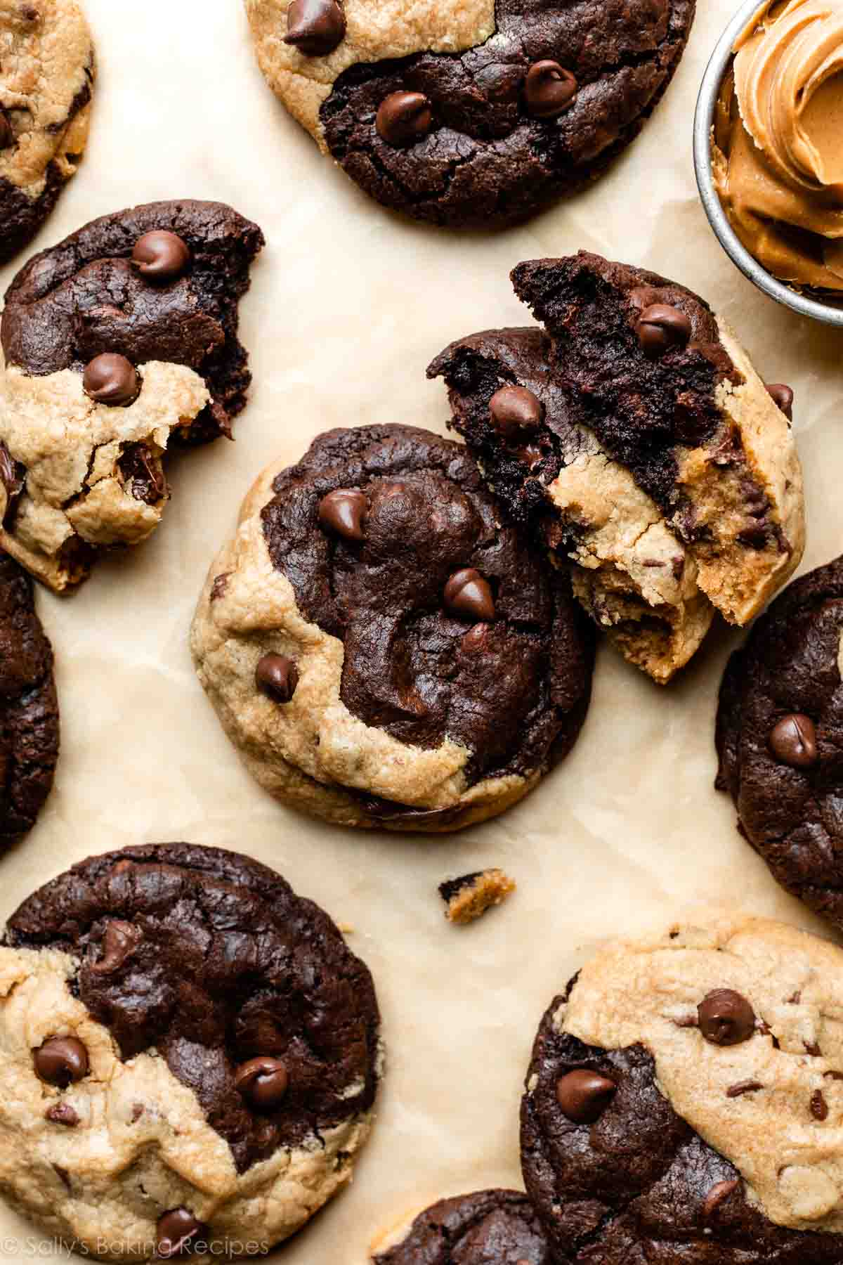 peanut butter chocolate swirl cookies on brown parchment paper with 2 broken in half.