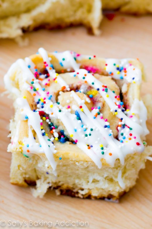 cake batter cinnamon roll topped with icing and sprinkles