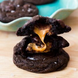 stack of dark chocolate cookies with sea salt and caramel with caramel showing