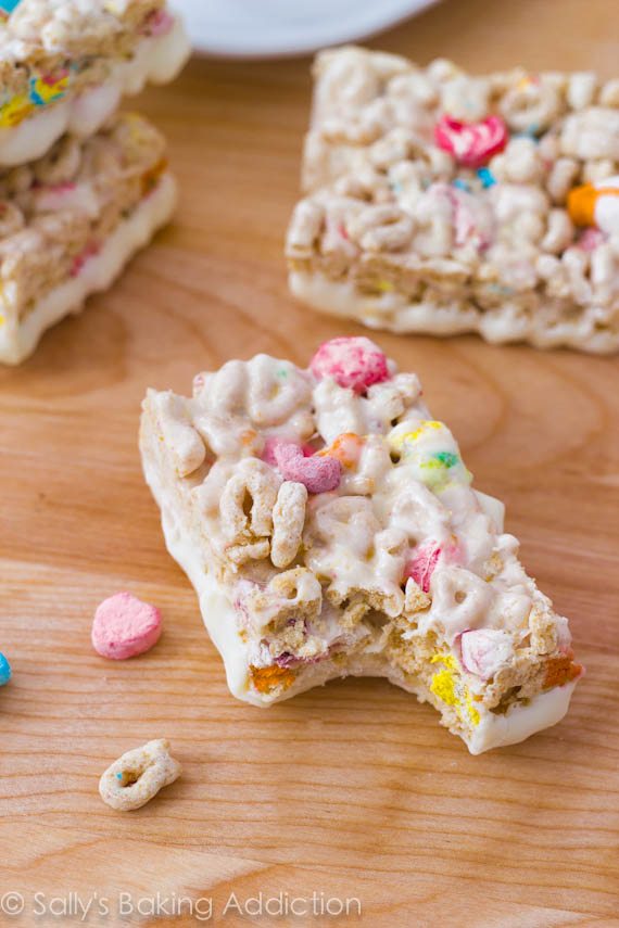 Lucky Charms Treats with the bottoms dipped in white chocolate with a bite taken from one