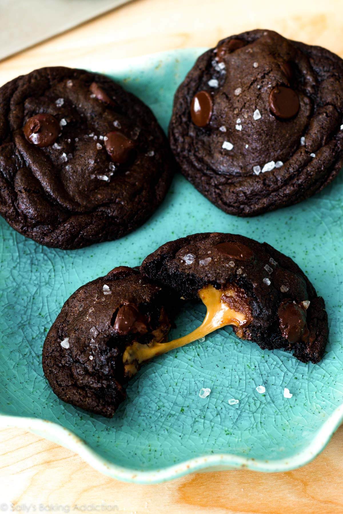 Dark chocolate cookies with sea salt and caramel on a teal plate
