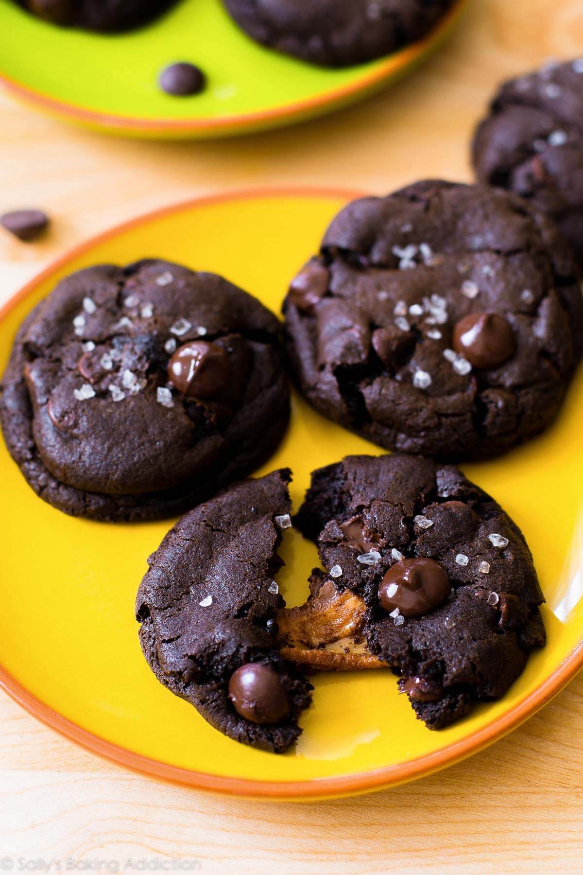 Dark chocolate cookies with sea salt and caramel on a yellow plate