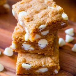 stack of biscoff white chocolate blondies on a wood board