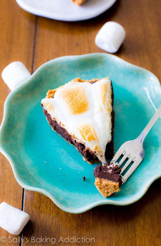 slice of s'mores brownie pie on a teal plate with a fork
