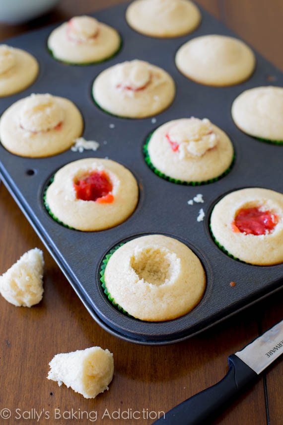 vanilla cupcakes with the centers cut out and strawberry filling in the centers