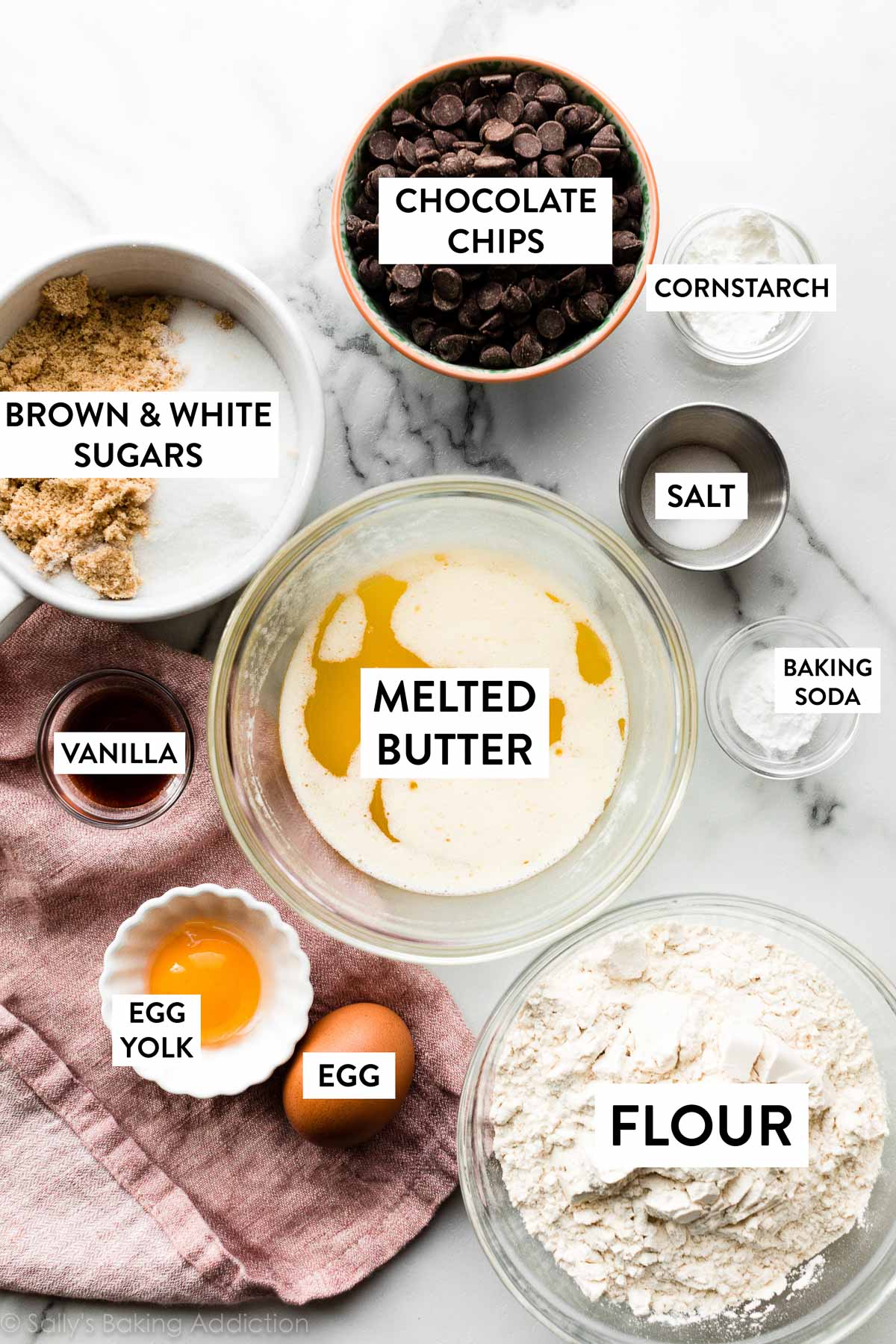 ingredientes en tazones que incluyen mantequilla derretida, chispas de chocolate, almidón de maíz, harina, vainilla y azúcares