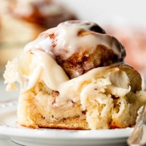 close-up photo of gooey cream cheese icing-topped cinnamon roll.