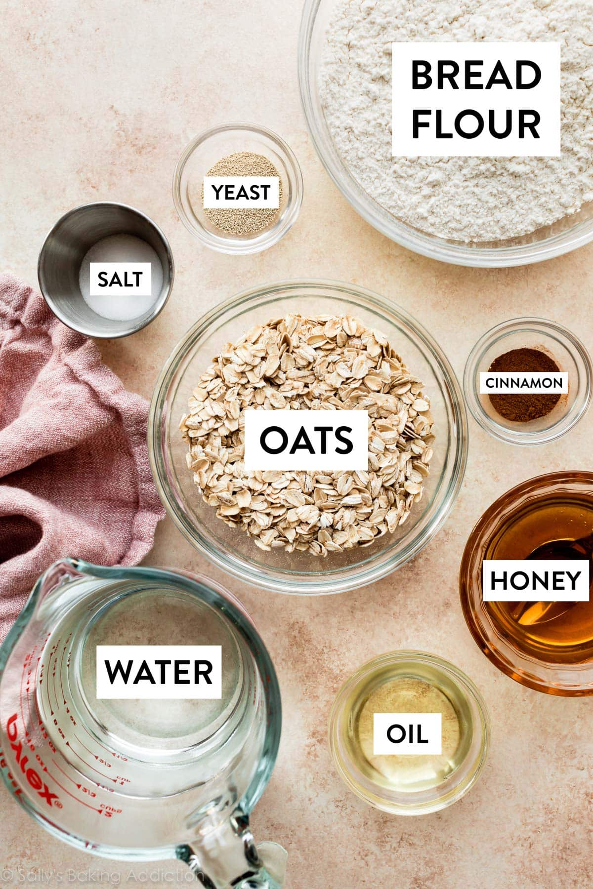 ingredients in bowls including honey, oats, yeast, salt, cinnamon, and bread flour