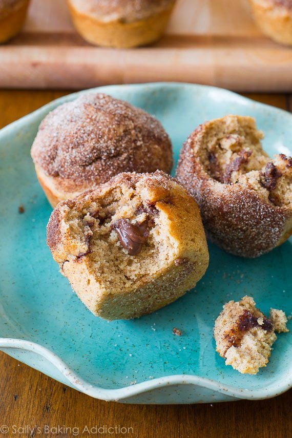 cinnamon sugar muffins stuffed with Nutella with a bite taken out of one showing the middle on a blue plate