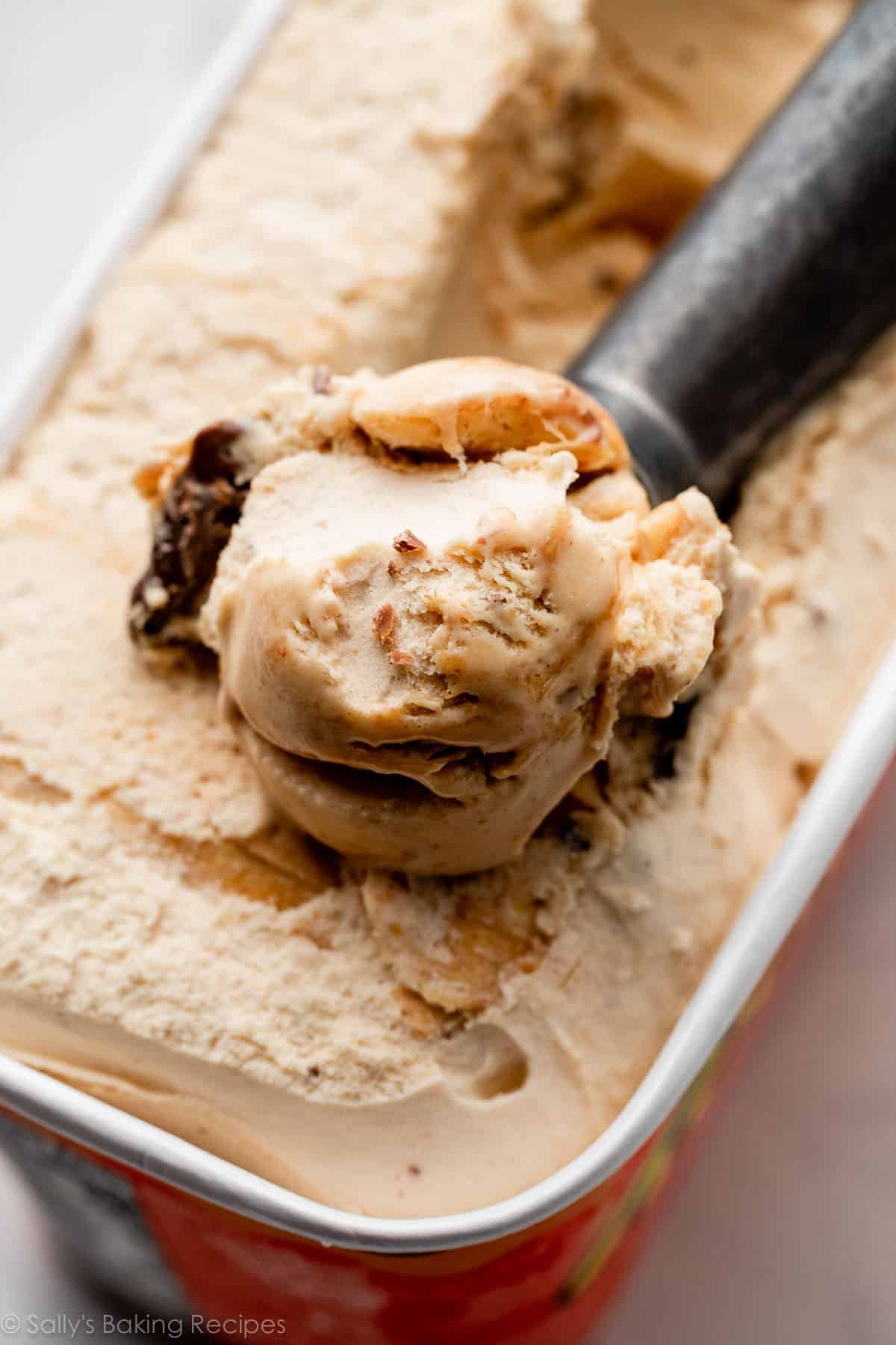 peanut butter ice cream being scooped out of carton with ice cream scoop.
