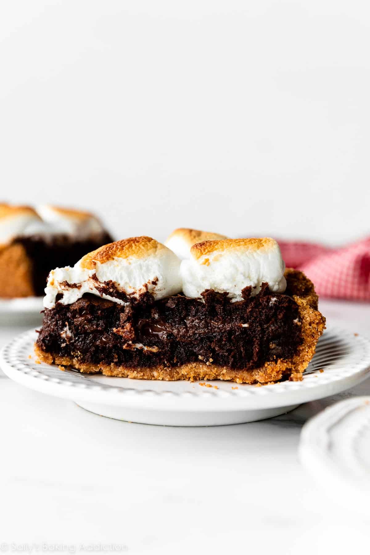 slice of s'mores brownie pie on white plate.