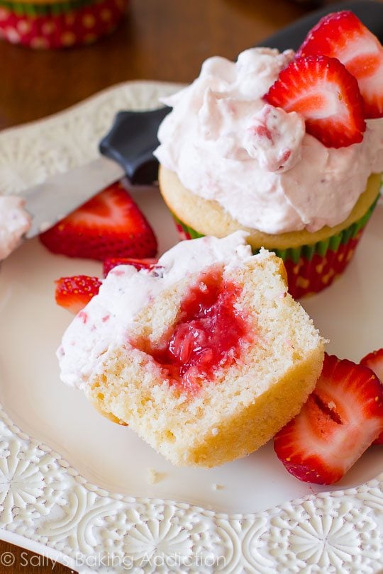 strawberry shortcake cupcake cut open showing the strawberry filling