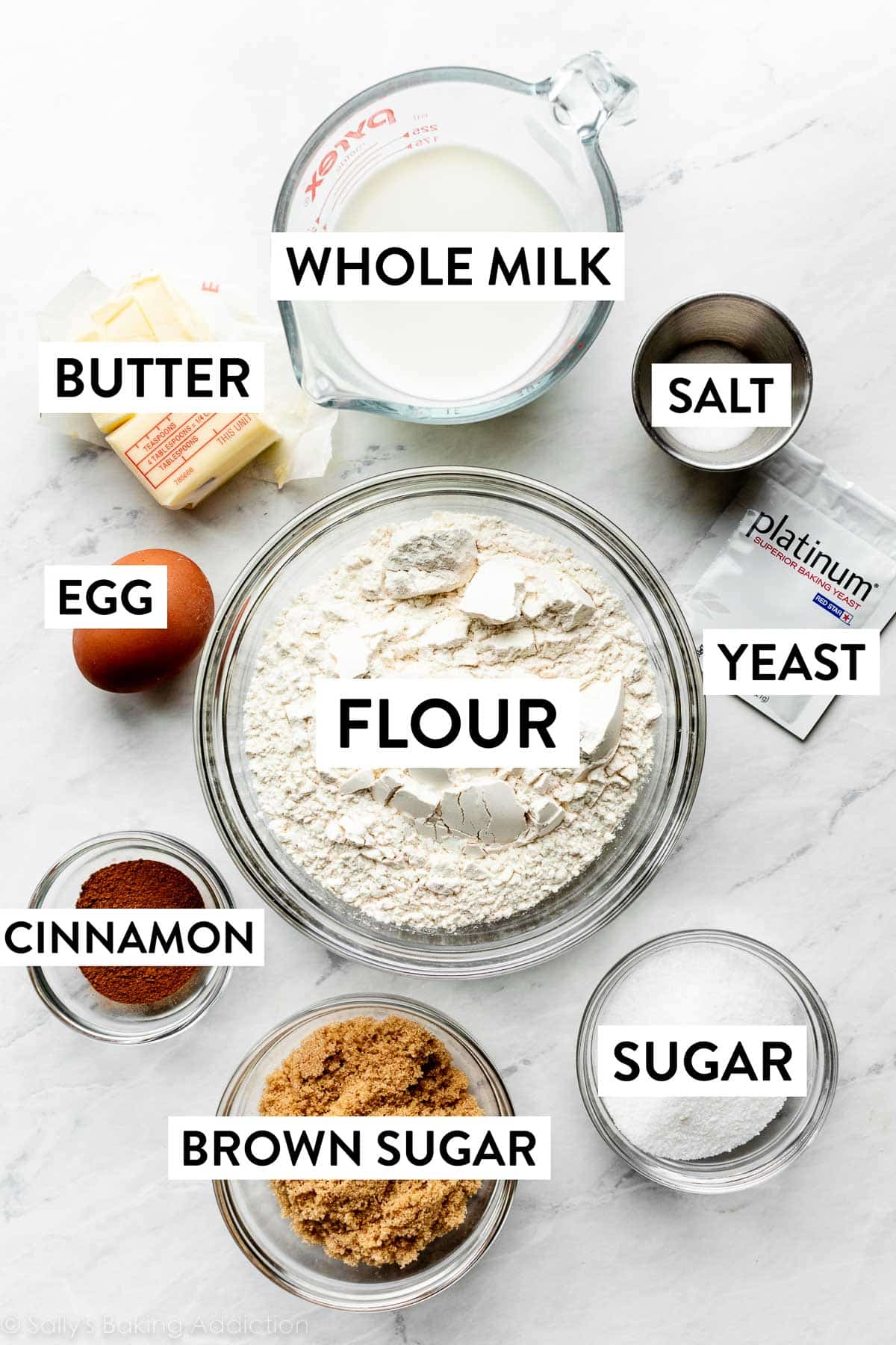 ingredients measured in different bowls including flour, whole milk, cinnamon, brown sugar, butter, and more.