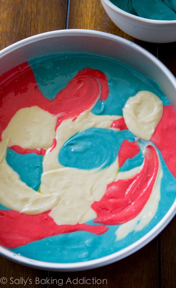 red, white, and blue tie-dye cake batter in a cake pan before baking